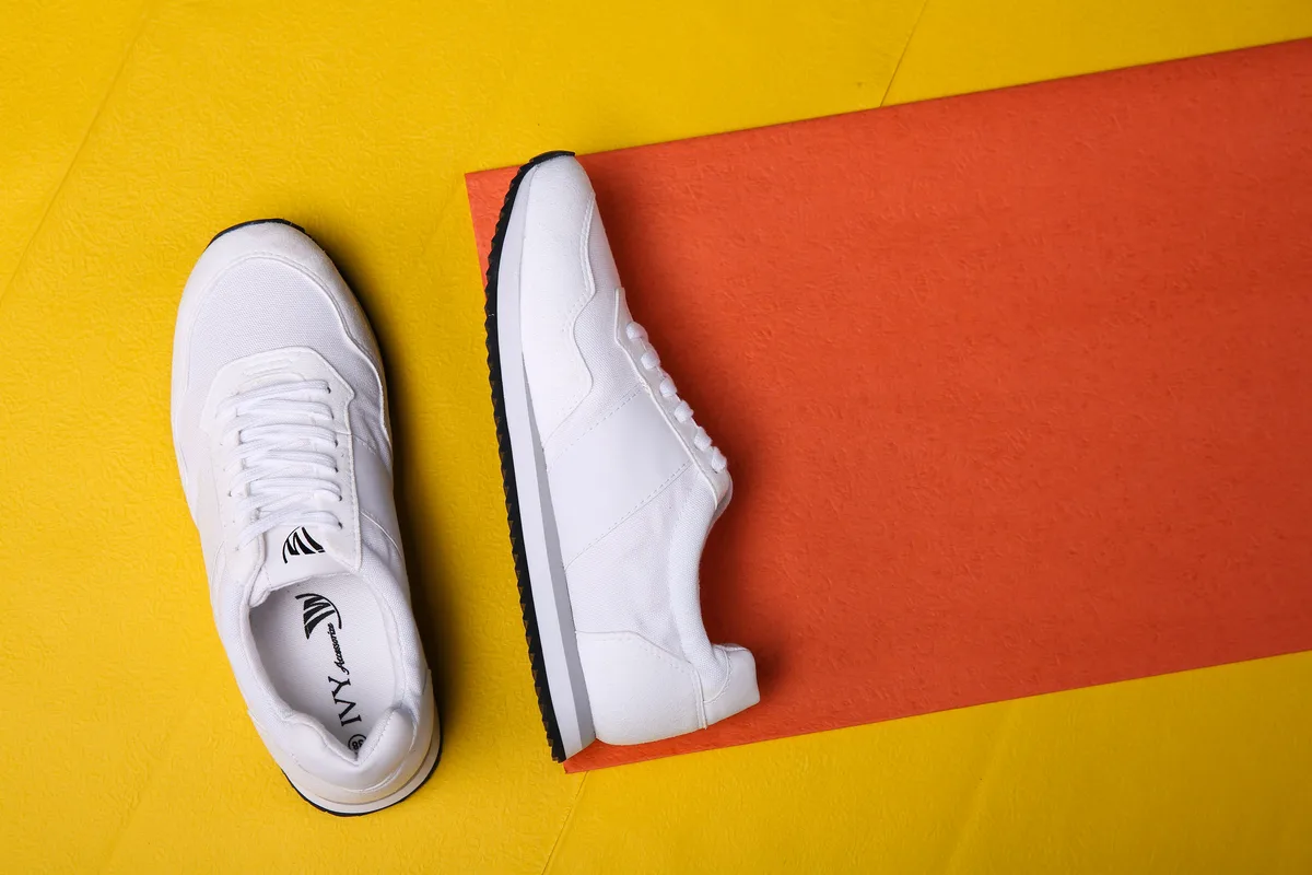White sneakers on a yellow and orange backdrop
